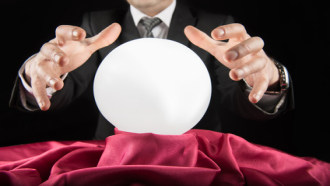 person dressed as a magician with hands over a crystal ball