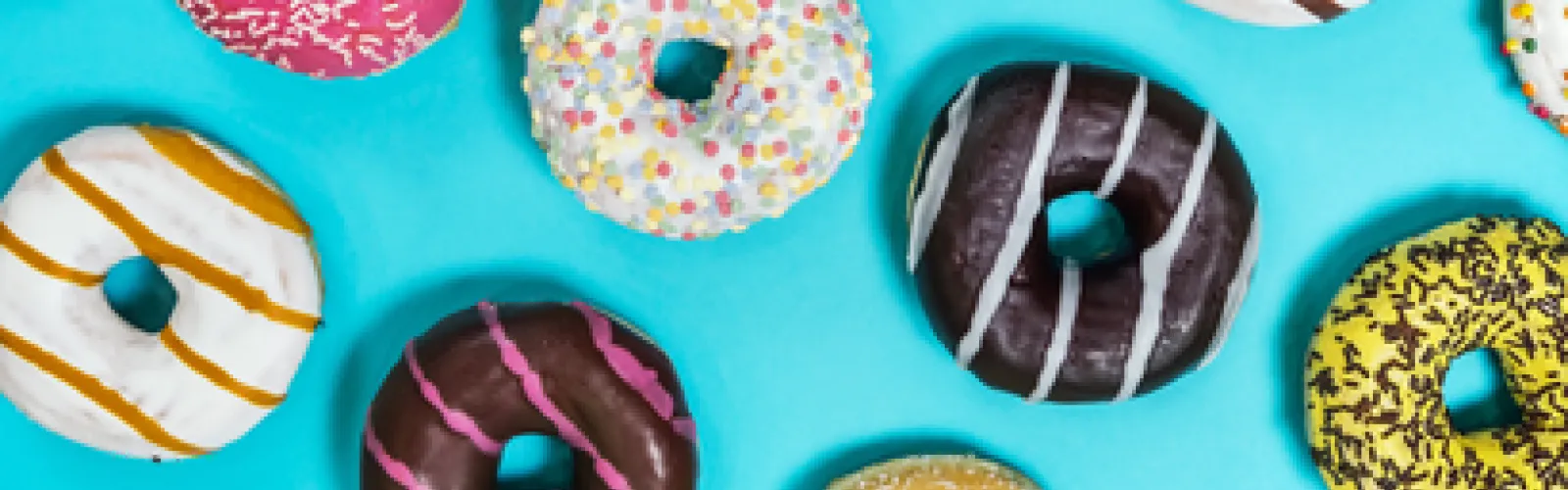 blue background with frosted donuts with stripes and sprinkles