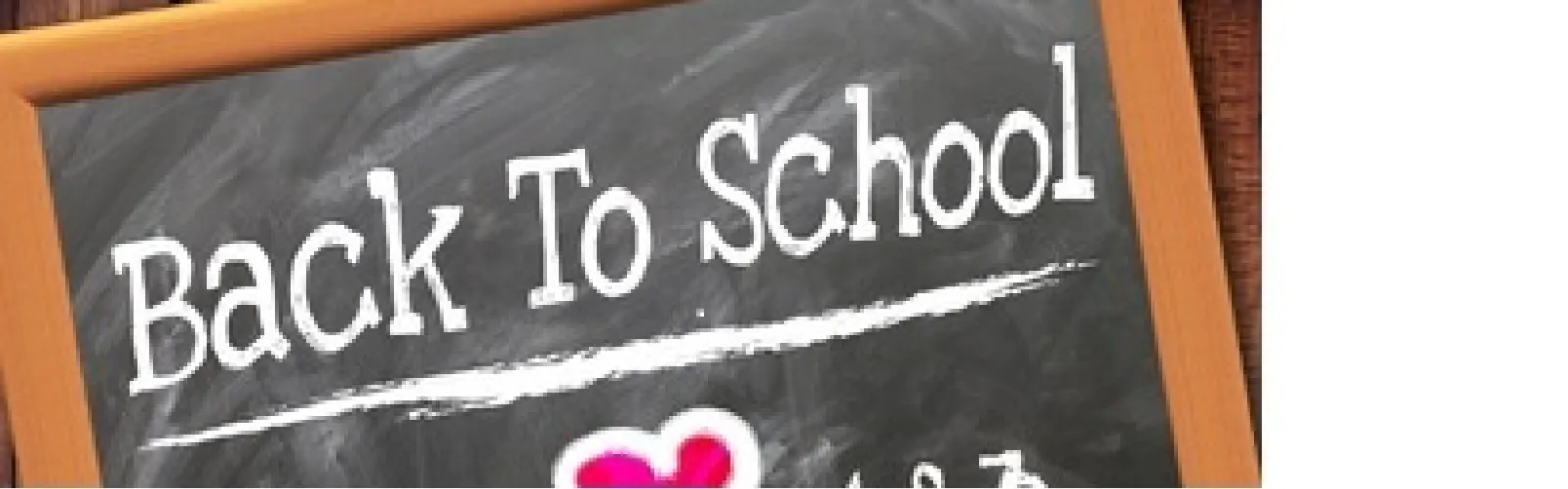 chalk board with back to school written in white chalk with red heart underneath