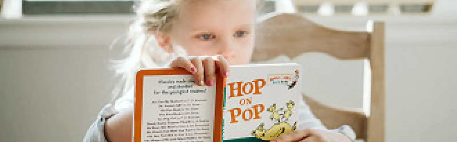 girl reading Hop on Pop book